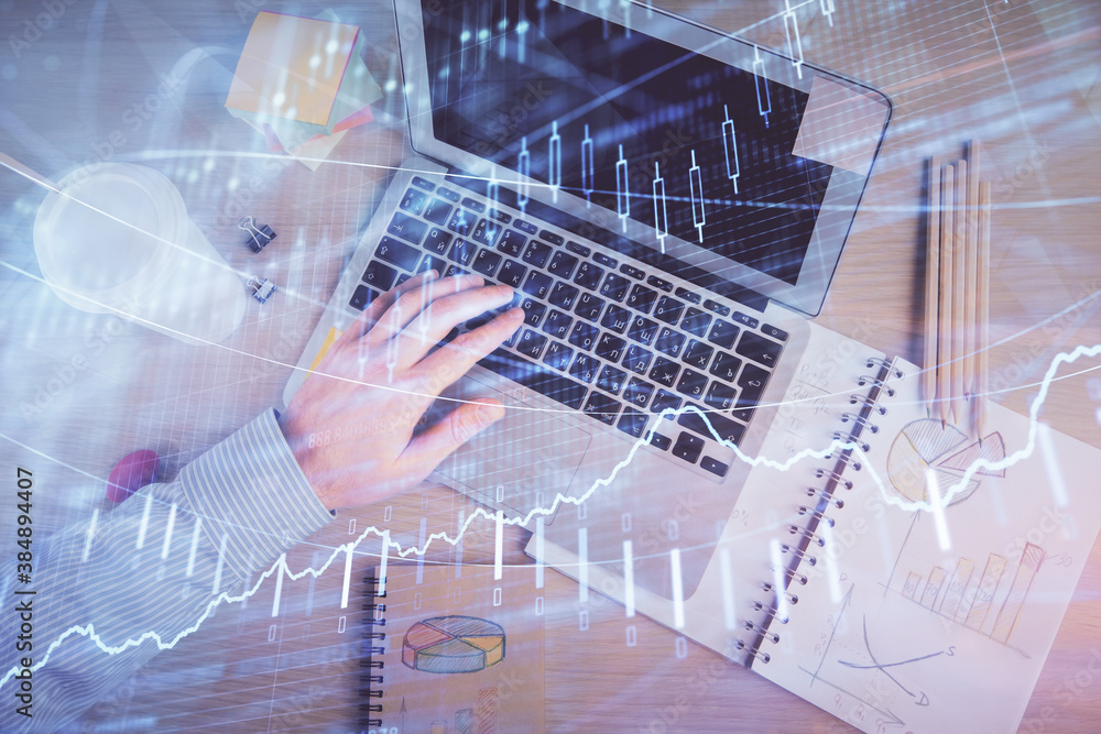 Double exposure of man's hands typing over computer keyboard and forex graph hologram drawing. Top view. Financial markets concept. Double exposure of man's hands typing over computer keyboard and forex graph hologram drawing. Top view. Financial markets concept.