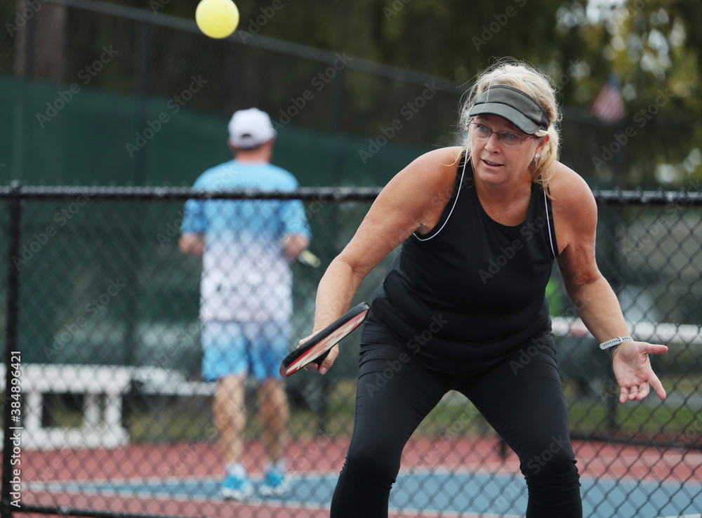 Senior woman competes in a pickleball tournament. Senior woman competes in a pickleball tournament.