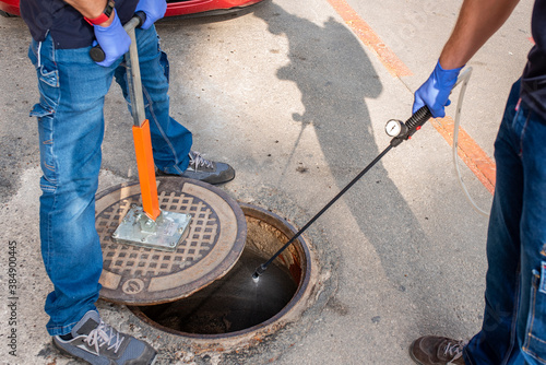 Cuadro en lienzo Person lifting sewer with magnet and disinfecting sewer