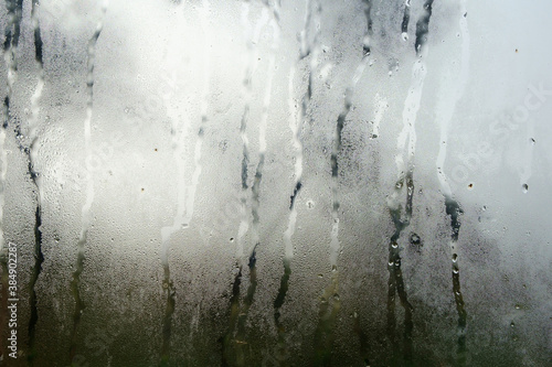 Texture of a fogged window. The first frosts, moisture condenses on the glass creating beautiful iridescent drops.