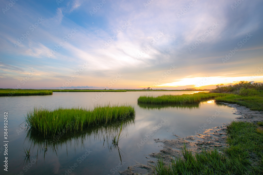 Sunset reflection with marsh grass waterway on the coast 