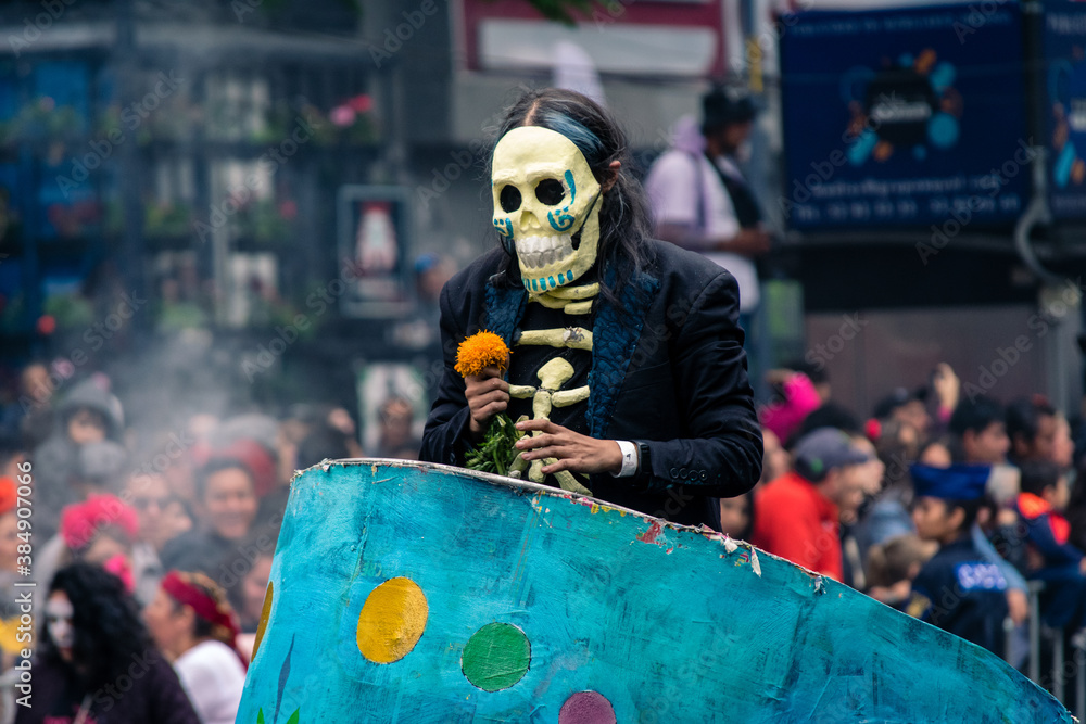 hombre con mascara de calavera y flor en festival de dia de muertos