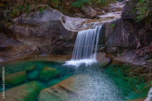 The turquoise color water creek and waterfalls in Emerald Valley, in Anhui province, China.