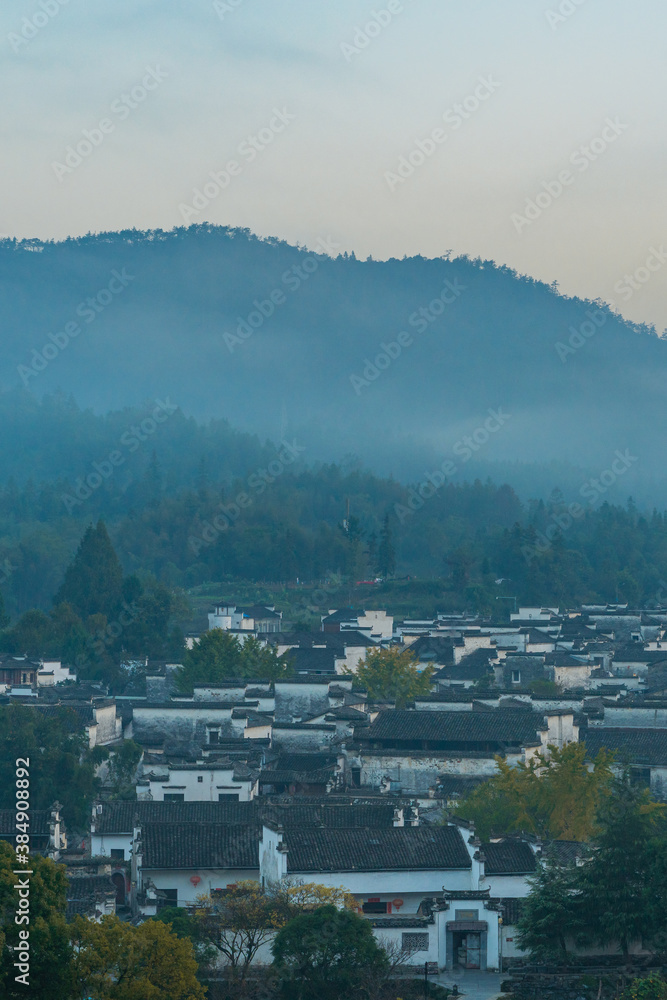  Panorama view of Xidi village, an ancient Chinese village in Anhui Province, China, a UNESCO world cultural heritage site, shot at sunrise with fog in the mountains.