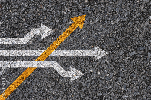 Foto Different thinking and Business and technology disruption concept , Yellow arrow cross direction with white arrow on road asphalt