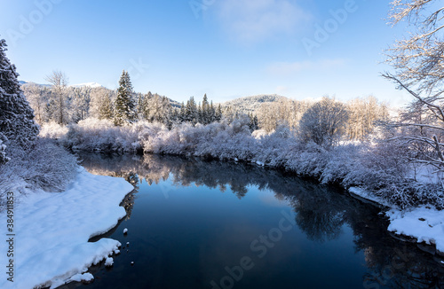 Winter river landscape. Snow covered riverbanks in frost sunny day © Victoria