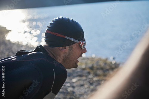 triathlon athlete starting swimming training on lake © .shock