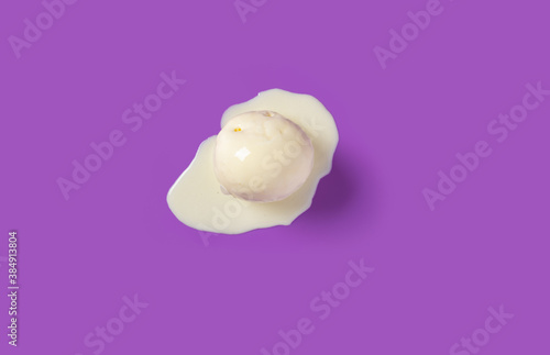 top view vanilla flavor ice cream ball starts melting on purple background