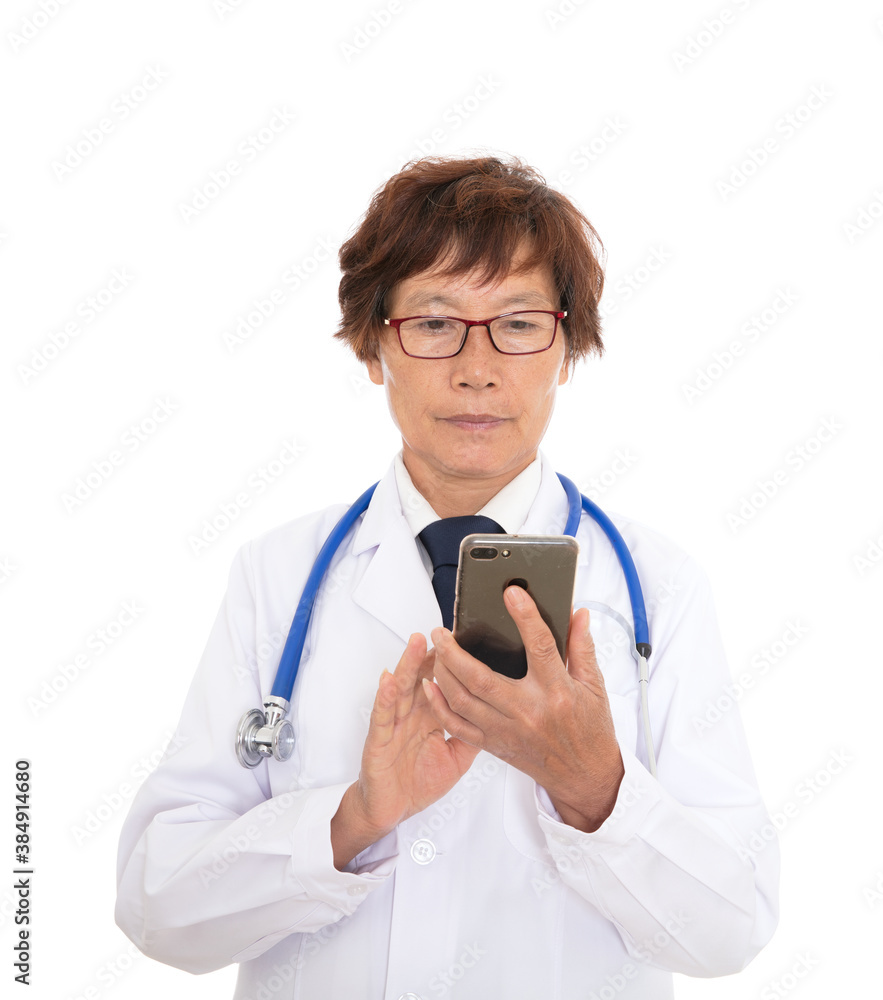 Chinese senior female doctor using mobile phone in front of white background Chinese senior female doctor using mobile phone in front of white background
