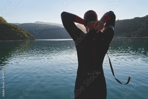 Fotografie triathlon athlete starting swimming training on lake