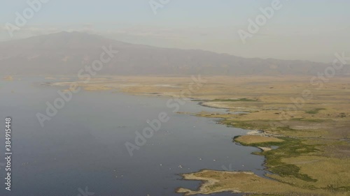 Aerial view of Tanzania. Drone flying over the shoreline of the salt lake Natron in the savannah with a background on the volcano Ol Doinyo Lengai . Aerial view of Tanzania. photo