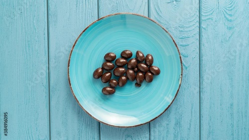 Chocolate candies dissapearing from a bowl. Stop motion. Top view. photo