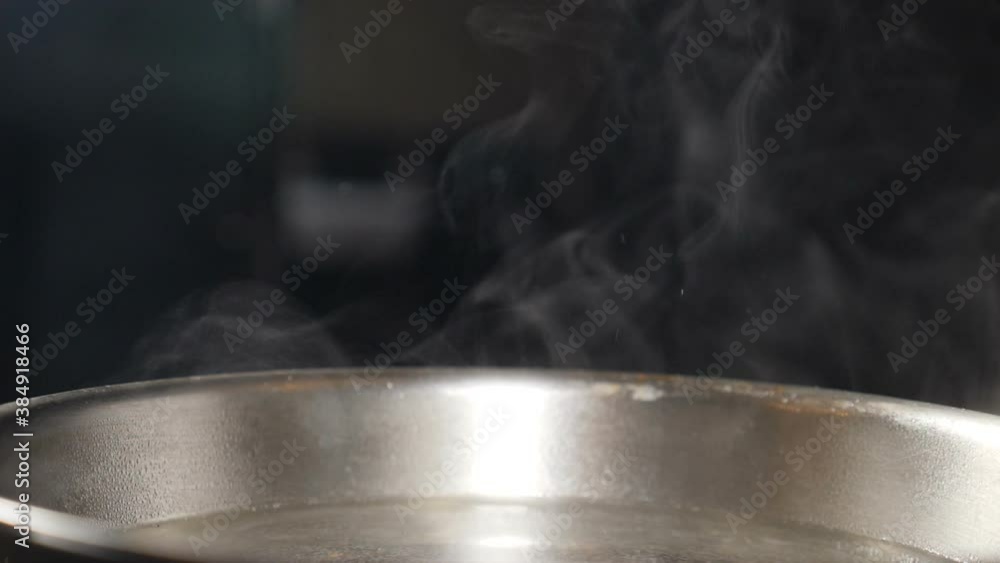 Steam or Vapour clouds rising from boiling steel frying pan on stove. Steam from pan while cooking. Cooking process in slow motion. Steam and white smoke rising on black background. Full hd Steam or Vapour clouds rising from boiling steel frying pan on stove. Steam from pan while cooking. Cooking process in slow motion. Steam and white smoke rising on black background. Full hd