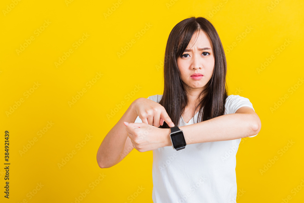 You are late not on time, Portrait Asian of a happy beautiful young woman scared casual girl showing and pointing finger her wristwatch studio shot isolated on yellow background You are late not on time, Portrait Asian of a happy beautiful young woman scared casual girl showing and pointing finger her wristwatch studio shot isolated on yellow background