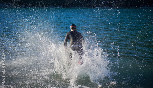 triathlon athlete starting swimming training on lake © .shock