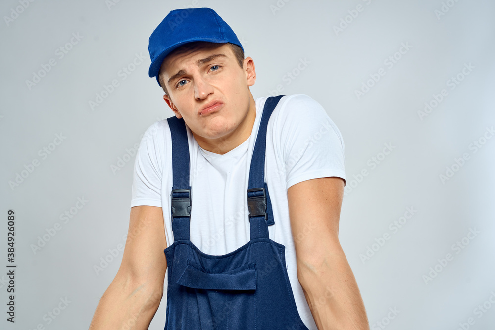 Man worker in forklift uniform delivery service light background Man worker in forklift uniform delivery service light background