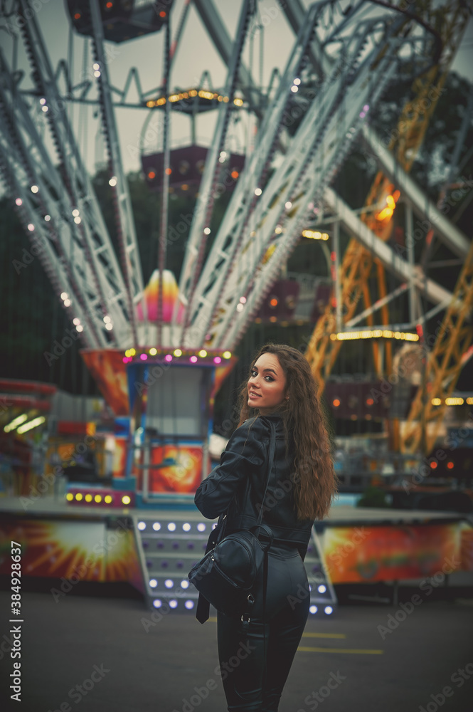 Portrait of a young woman in an evening amusement park