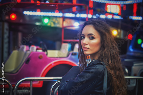 Portrait of a young woman in an evening amusement park