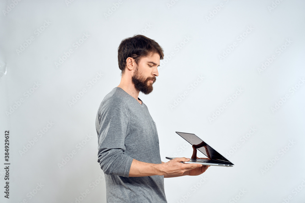 Emotional man holding a laptop success modern style work light background Emotional man holding a laptop success modern style work light background