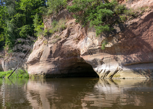 beautiful day on the river, sandstone cliffs and tree reflections in the water, blue sky reflected in the river water