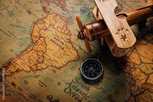 Fotografía Old compass discovery and wooden plane on vintage paper antique world map backgr
