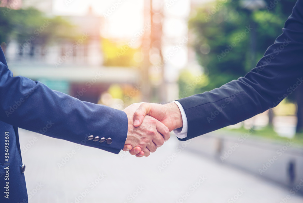Fototapeta premium Team Business Partners shaking hands together to Greeting Start up new project. Shakehand Teamwork Partnership outside office modern city background. Businessman handshake together. Business concept