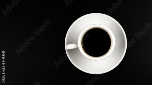 Top view of white cup with coffee and saucers