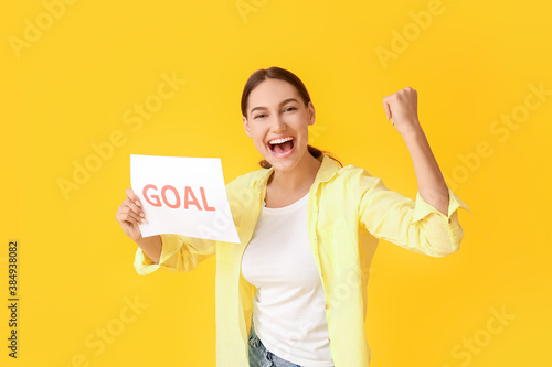Happy young woman holding p...
