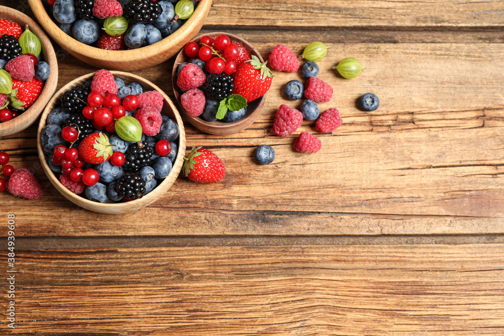 Mix of ripe berries on wooden table, flat lay. Space for text Mix of ripe berries on wooden table, flat lay. Space for text