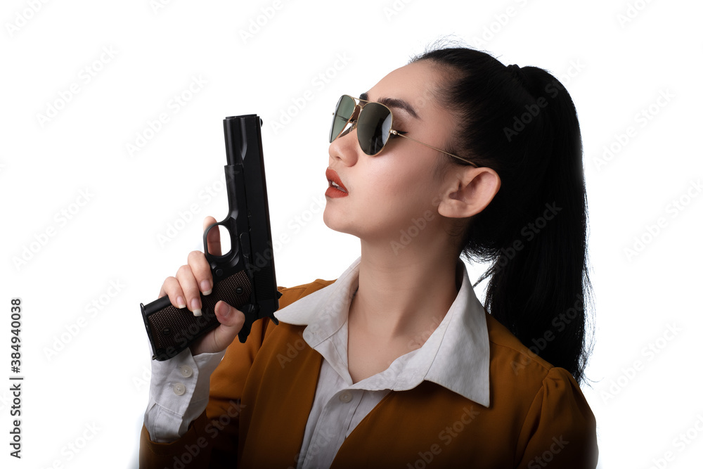 Portrait beautiful Asia woman wearing a yellow suit one hand holding a pistol gun at the white background Portrait beautiful Asia woman wearing a yellow suit one hand holding a pistol gun at the white background