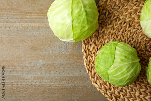 Ripe white cabbage on wooden table, flat lay. Space for text