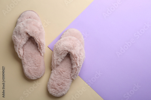 Pair of stylish soft slippers on color background, flat lay. Space for text