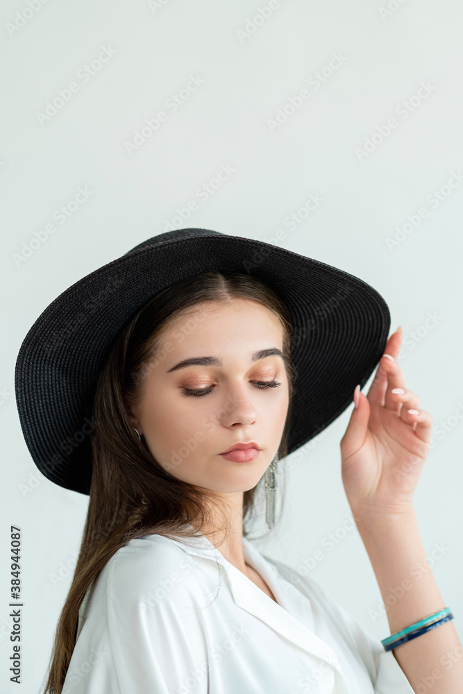 Summer look. Fashion trends. Stylish romantic woman in straw black hat white shirt posing elegantly isolated on neutral copy space. Model shooting. Style mixing Summer look. Fashion trends. Stylish romantic woman in straw black hat white shirt posing elegantly isolated on neutral copy space. Model shooting. Style mixing