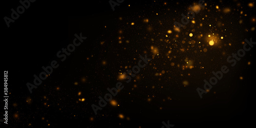 Abstract background with golden glitter dust. Glowing lights, sparkling particles on black.