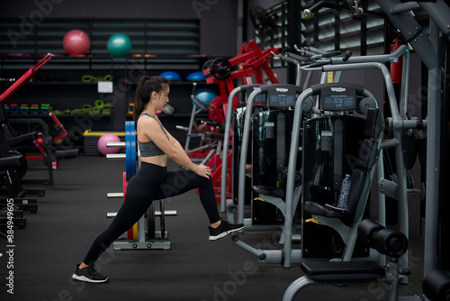 Fitness woman doing stretching workout. Young women warm up at gym.