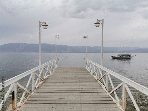 Walking path towards the lake. Lake, boat, sky and clouds. © iskenderkabul