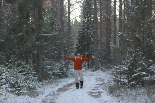 winter landscape forest backpack man / traveler in modern winter clothes in the forest, traveling in the mountains  europe, switzerland winter photo