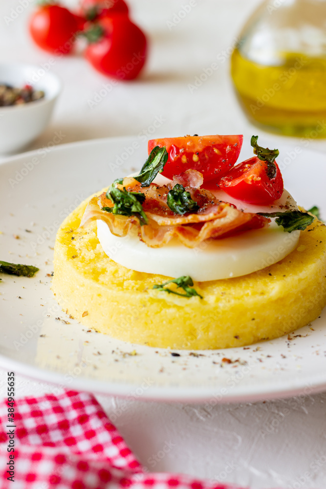 Polenta with mozzarella, bacon and tomatoes. Italian cuisine. Recipe.