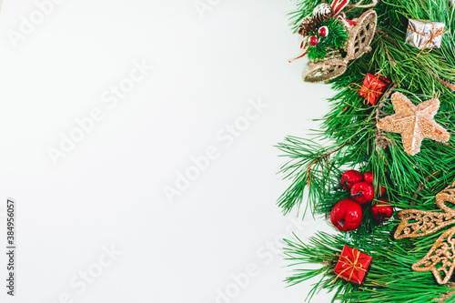 Pine branches and red and gold Christmas decorations on a white background. Christmas background. Copy space.