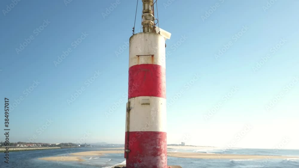 The two sides of Restinga de Ofir. The Ronca de Esposende, a red and white colored beacon alerts on the pier, Portugal. The two sides of Restinga de Ofir. The Ronca de Esposende, a red and white colored beacon alerts on the pier, Portugal.