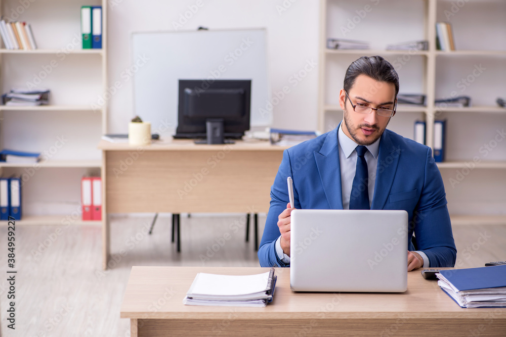 Young male businessman employee working in the office Young male businessman employee working in the office