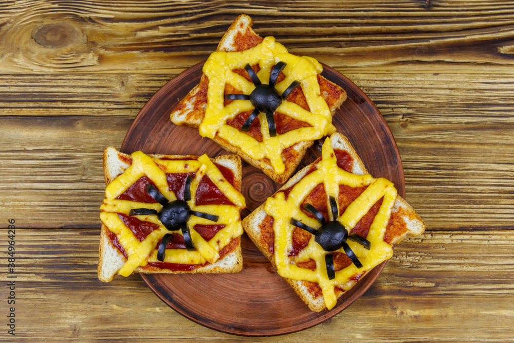 Funny sandwiches with spider and spider web for Halloween party on wooden table. Top view Funny sandwiches with spider and spider web for Halloween party on wooden table. Top view