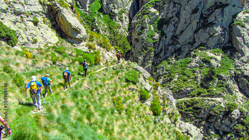 People hiking in Vall de Nuria in the Catalonia pyrenees mountain during summer. Outdoor trekking activity and adventure. photo