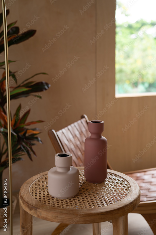Stylish living corner with rattan leather chair setting with wood and artificial plant in glass vase with plywood wall on the background / cozy interior design / modern interior Stylish living corner with rattan leather chair setting with wood and artificial plant in glass vase with plywood wall on the background / cozy interior design / modern interior