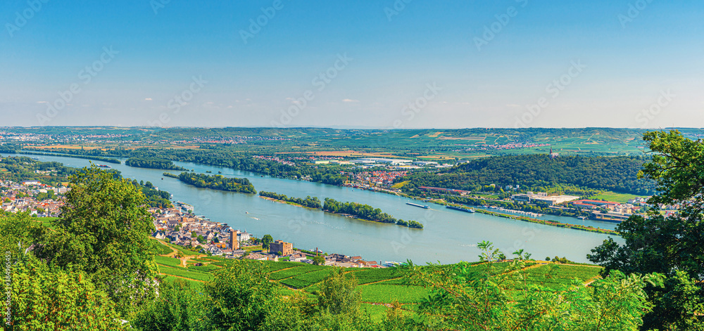 Panorama of river Rhine Gorge or Upper Middle Rhine Valley winemaking region with vineyards green fields near Rudesheim am Rhein town, Rhineland-Palatinate, Germany. Panoramic view of Rhein valley
