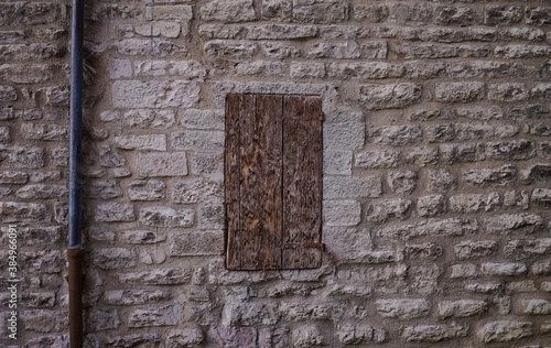 An isolated window with old wooden shutters of an abandoned medieval building with stone walls  Gubbio  Umbria  Italy  Europe 
