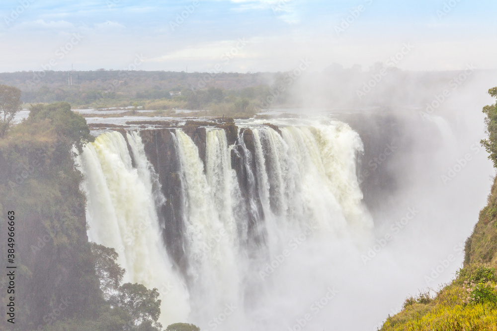 Victoria Falls, a waterfall in southern Africa at the Zambezi River at the border between Zambia and Zimbabwe. Milky water Victoria Falls, a waterfall in southern Africa at the Zambezi River at the border between Zambia and Zimbabwe. Milky water