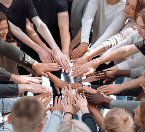 group of diverse people joining their hands in a circle.