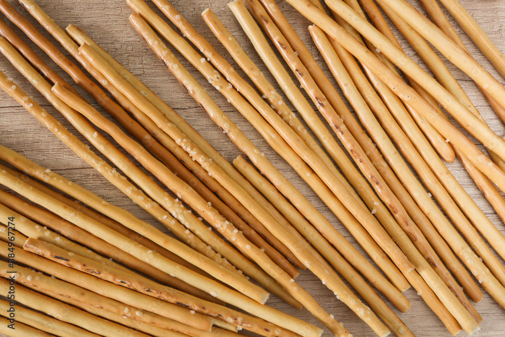 Salty or sweet straw from dough, snack from crackers, crispy breadsticks, close up background Salty or sweet straw from dough, snack from crackers, crispy breadsticks, close up background