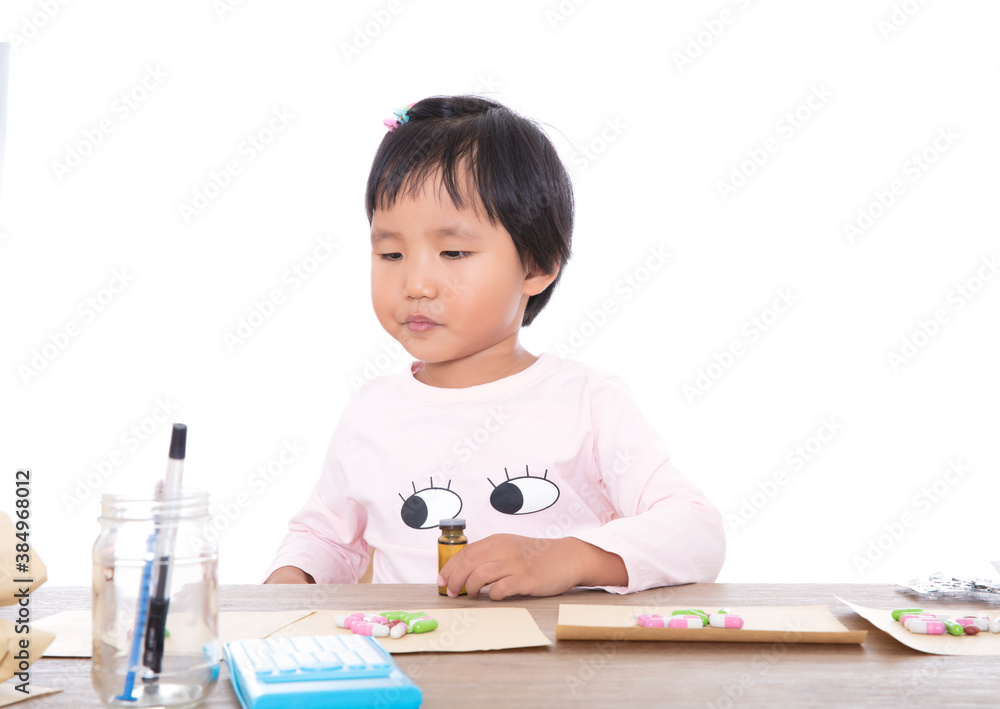The little girl playing the role of a doctor is dispensing medicine to the patient The little girl playing the role of a doctor is dispensing medicine to the patient